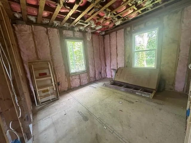 a view of an empty room with a fireplace and a window