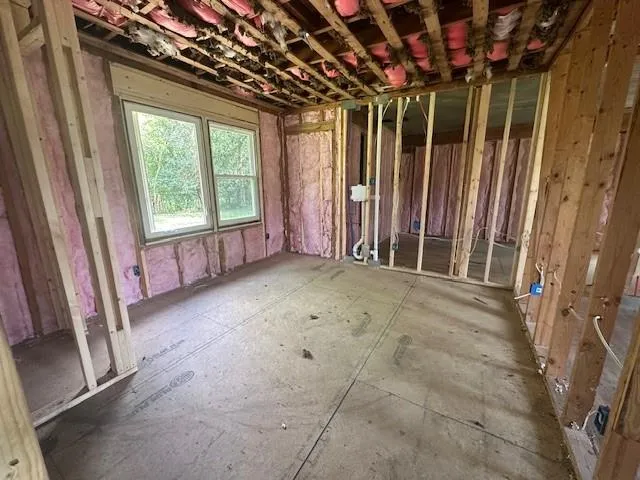 a view of an empty room with a fireplace and a window