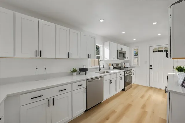 a kitchen with granite countertop white cabinets and white appliances