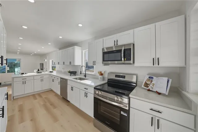 a kitchen with appliances a sink and cabinets
