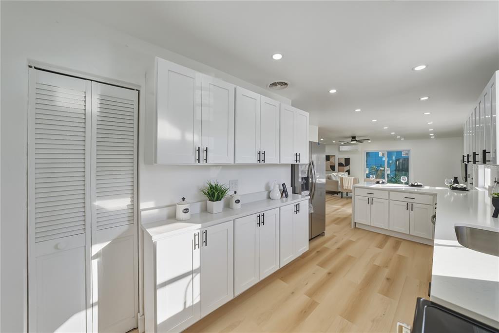 542 64th Street South St. Petersburg, FL 33707 - Photo 17 of 49 a kitchen with white cabinets and white appliances