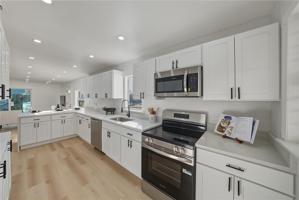 542 64th Street South St. Petersburg, FL 33707 - Photo 17 of 53 a kitchen with appliances a sink and cabinets