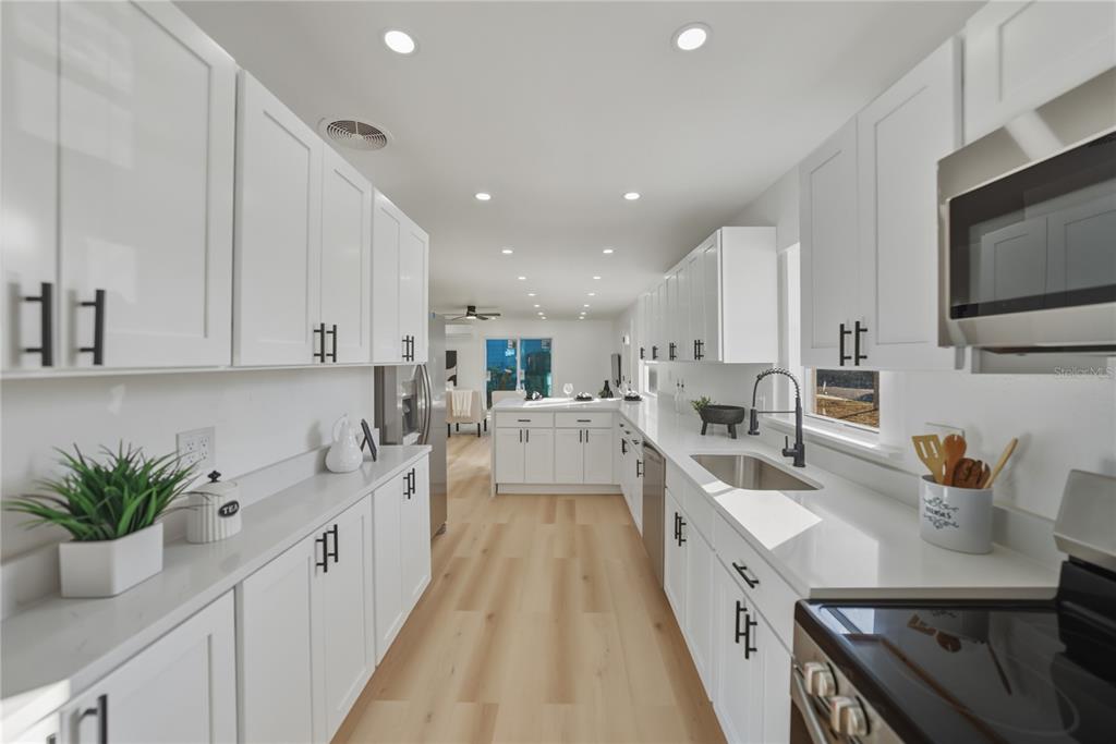 542 64th Street South St. Petersburg, FL 33707 - Photo 19 of 53 a large white kitchen with stainless steel appliances lots of counter space and a sink