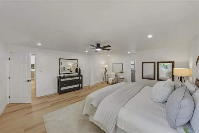 a spacious bedroom with a bed and a chandelier