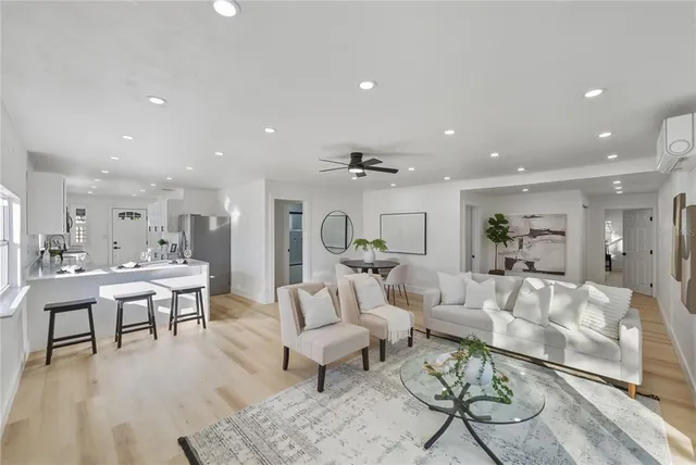 a living room with furniture and a dining table with wooden floor