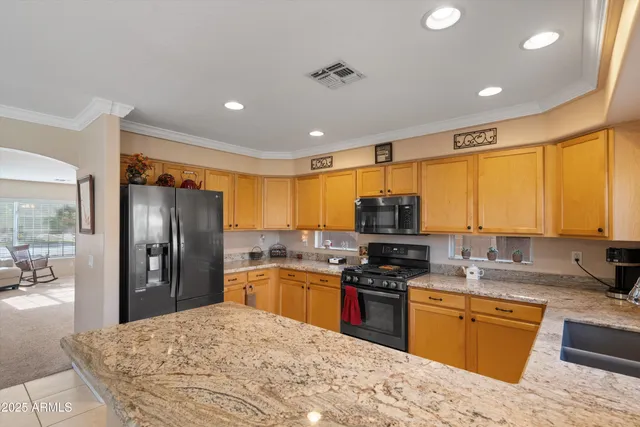 a kitchen with stainless steel appliances granite countertop a refrigerator stove top oven and sink