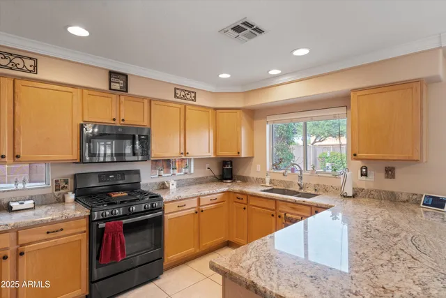a kitchen with stainless steel appliances granite countertop a stove sink and cabinets