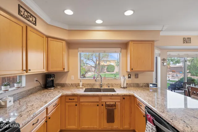 a kitchen with large windows sink and cabinets