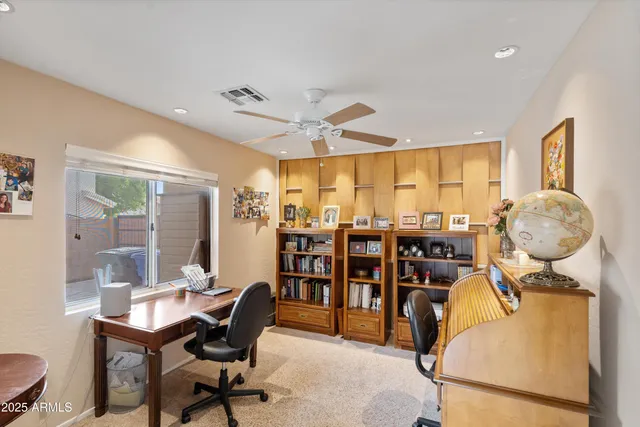a view of a workspace with furniture and a large window