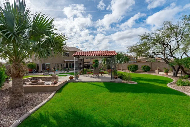 a view of a house with backyard and wooden fence