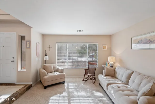 a living room with furniture and a floor to ceiling window