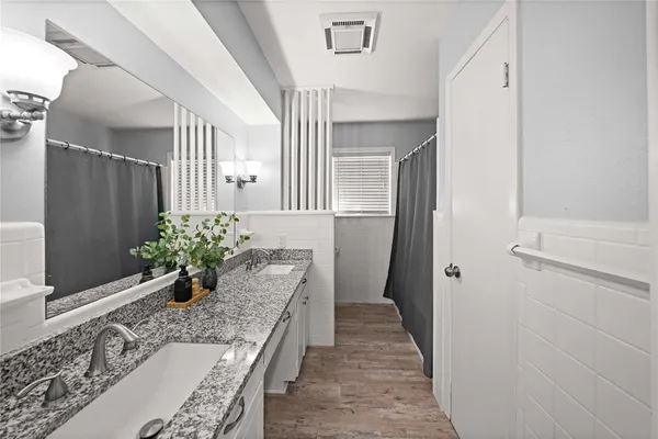 a room with a granite countertop furniture a potted plant and a wooden floor