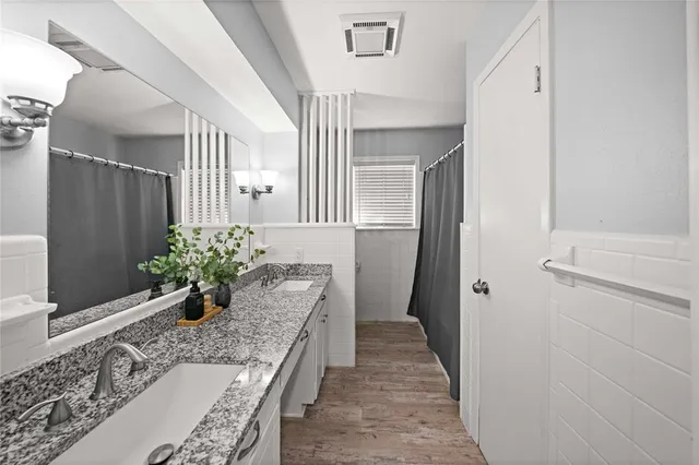 a room with a granite countertop furniture a potted plant and a wooden floor