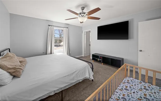 a bedroom with bed tv and window