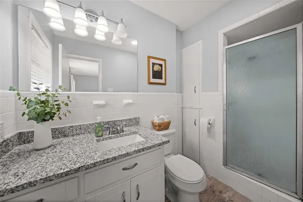 a bathroom with a granite countertop sink a toilet and mirror
