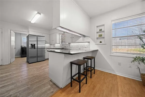a kitchen with stainless steel appliances granite countertop a kitchen island hardwood floor and a sink