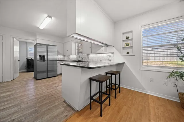 a kitchen with stainless steel appliances granite countertop a kitchen island hardwood floor and a sink