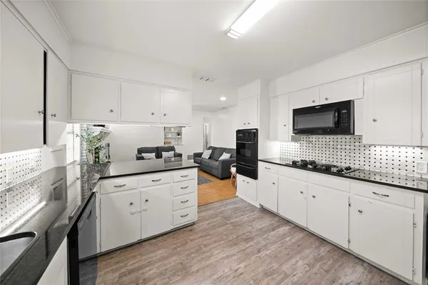 a kitchen with granite countertop white cabinets and white appliances