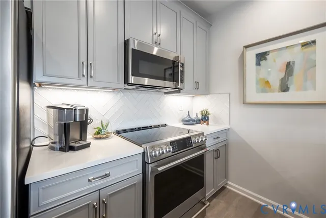 a kitchen with stainless steel appliances granite countertop a stove microwave and sink