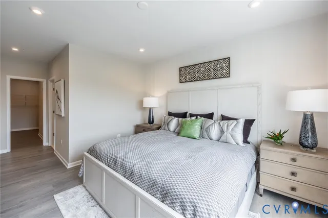 a bedroom with a bed and a lamp on dresser