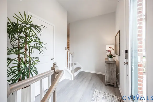 a view of a hallway with wooden floor and a potted plant