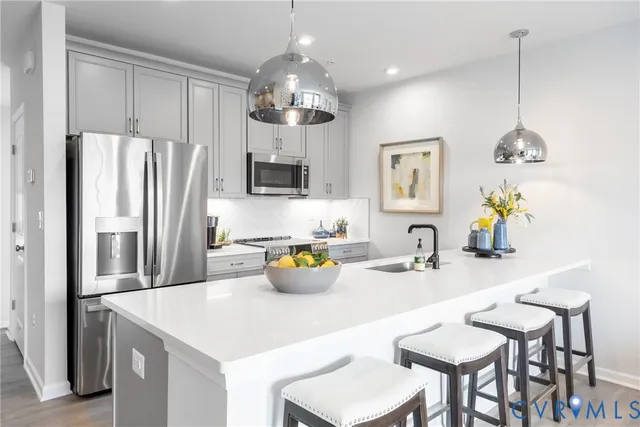 a kitchen with a sink a refrigerator and chairs