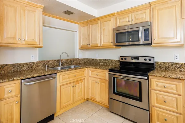 a kitchen with granite countertop white cabinets stainless steel appliances