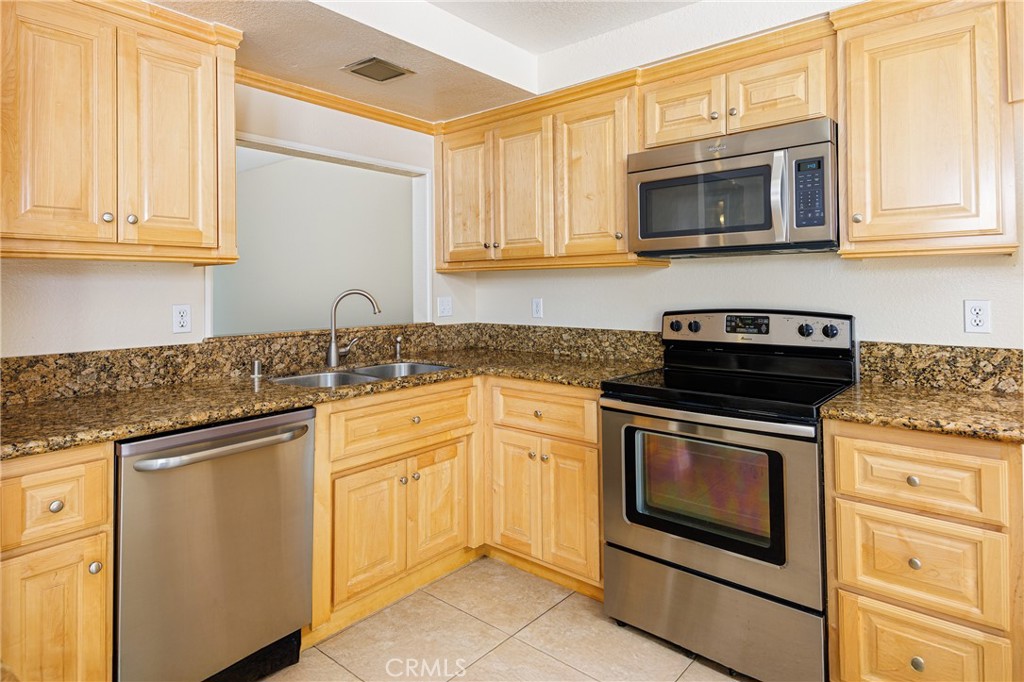 25885 Trabuco Road, Unit 206 Lake Forest, CA 92630 - Photo 8 of 40 a kitchen with granite countertop white cabinets stainless steel appliances