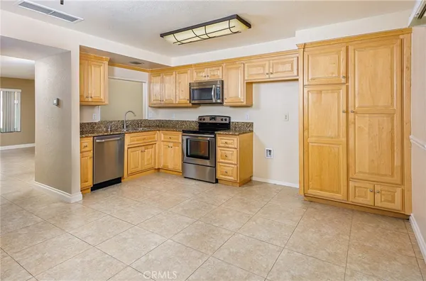 a kitchen with stainless steel appliances granite countertop a stove top oven a sink and dishwasher