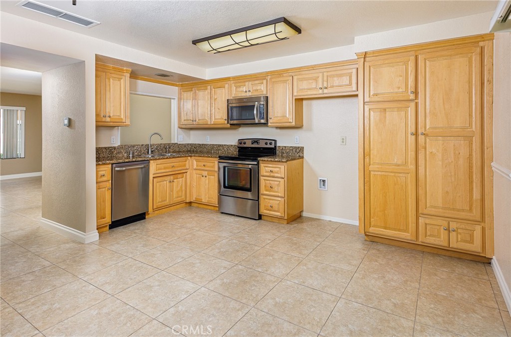 25885 Trabuco Road, Unit 206 Lake Forest, CA 92630 - Photo 9 of 40 a kitchen with stainless steel appliances granite countertop a stove top oven a sink and dishwasher
