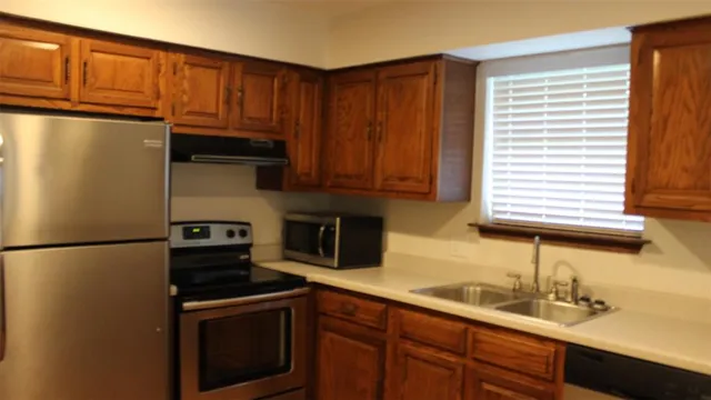a kitchen with stainless steel appliances granite countertop a refrigerator sink and cabinets