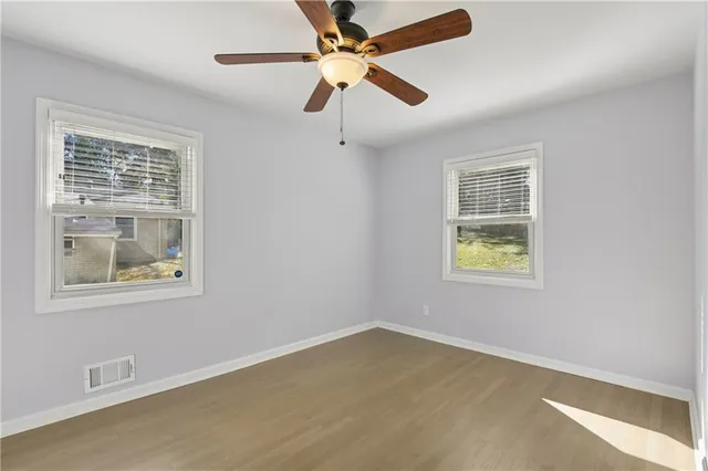 an empty room with a window and a fan
