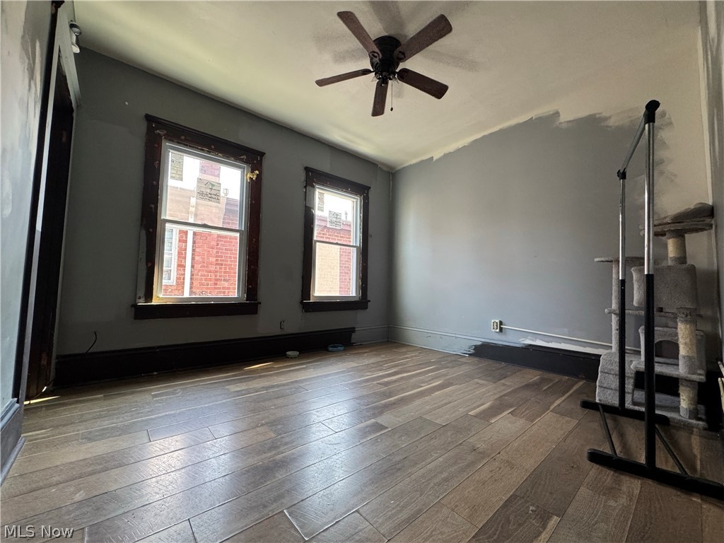 709 Fulton Road Northwest Canton, OH 44703 - Photo 14 of 20 Spacious bedroom featuring wood-finish flooring, two large windows, a ceiling fan, and dark trim details