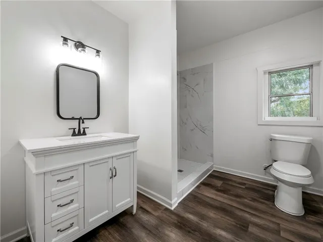 a bathroom with a sink a toilet and shower