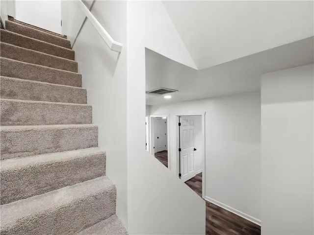 an empty room with wooden floor ceiling fan and windows