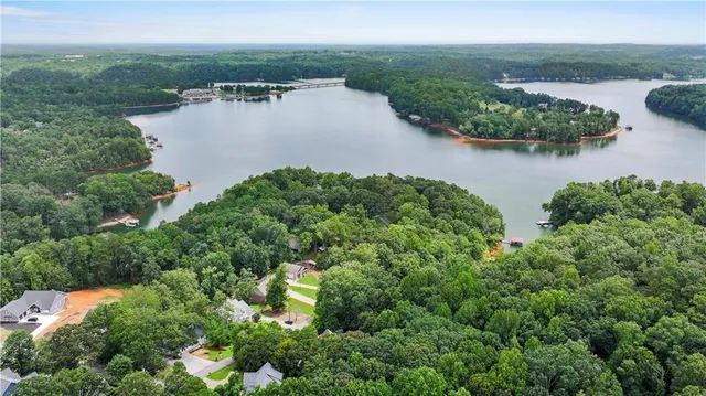 an aerial view of lake residential house with outdoor space and trees around