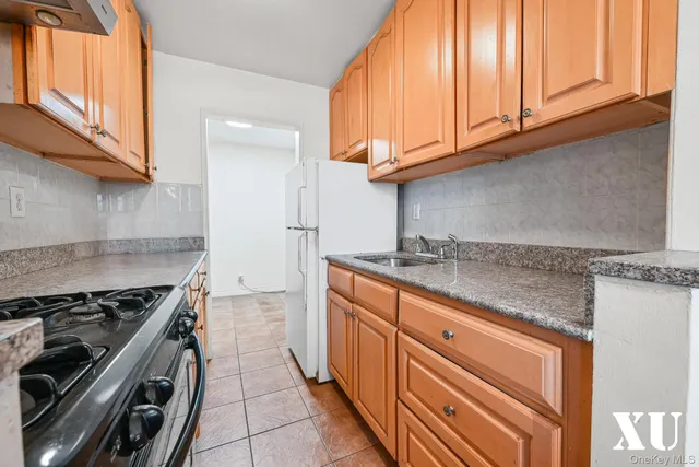 a kitchen with granite countertop a sink stove and cabinets