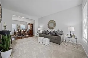 a living room with furniture a chandelier and a window