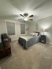 a spacious bedroom with a bed and a chandelier