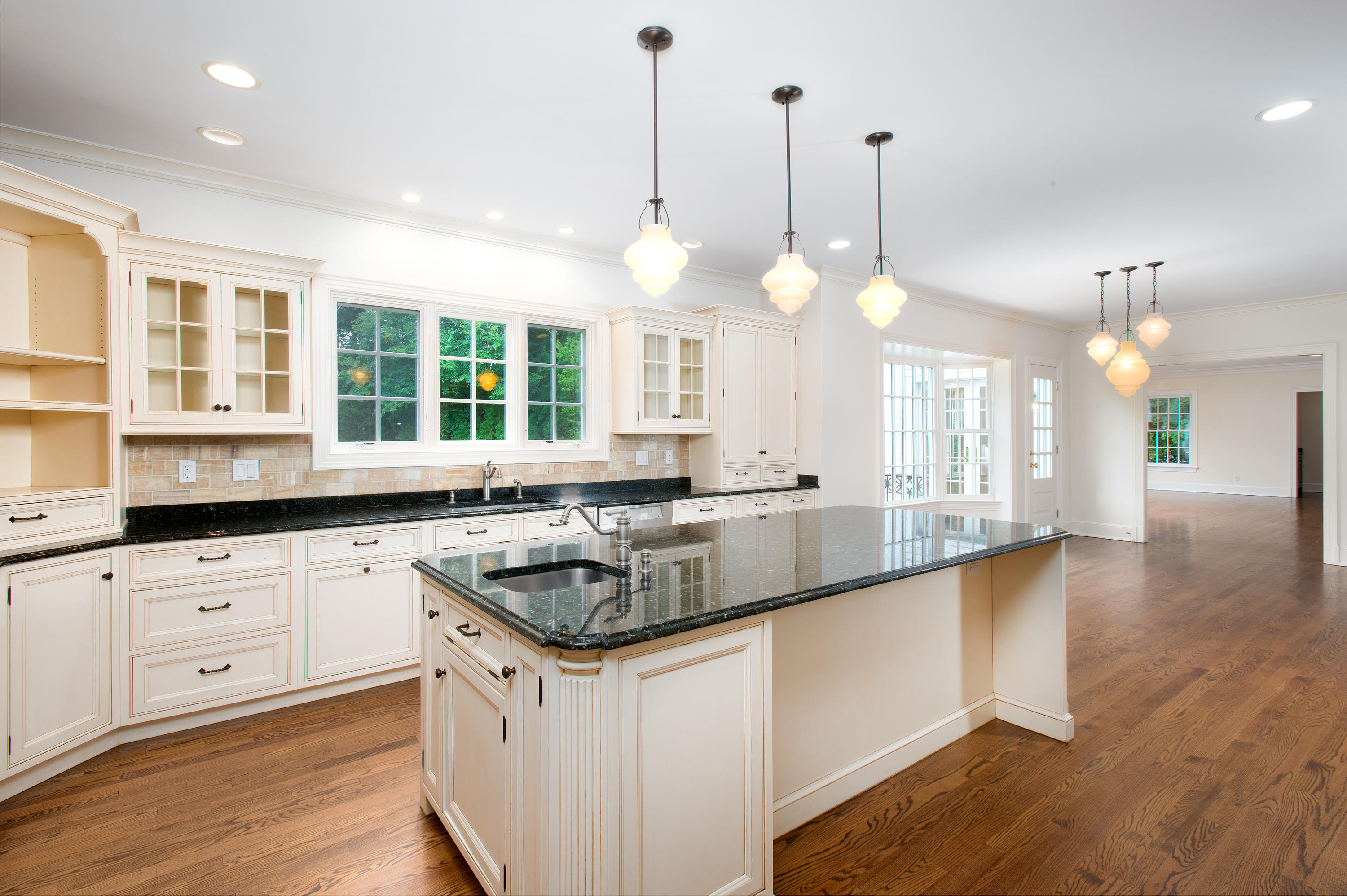 399 Wahackme Road New Canaan, CT 06840 - Photo 13 of 35 a kitchen with granite countertop a stove a sink a center island a dining table and chairs