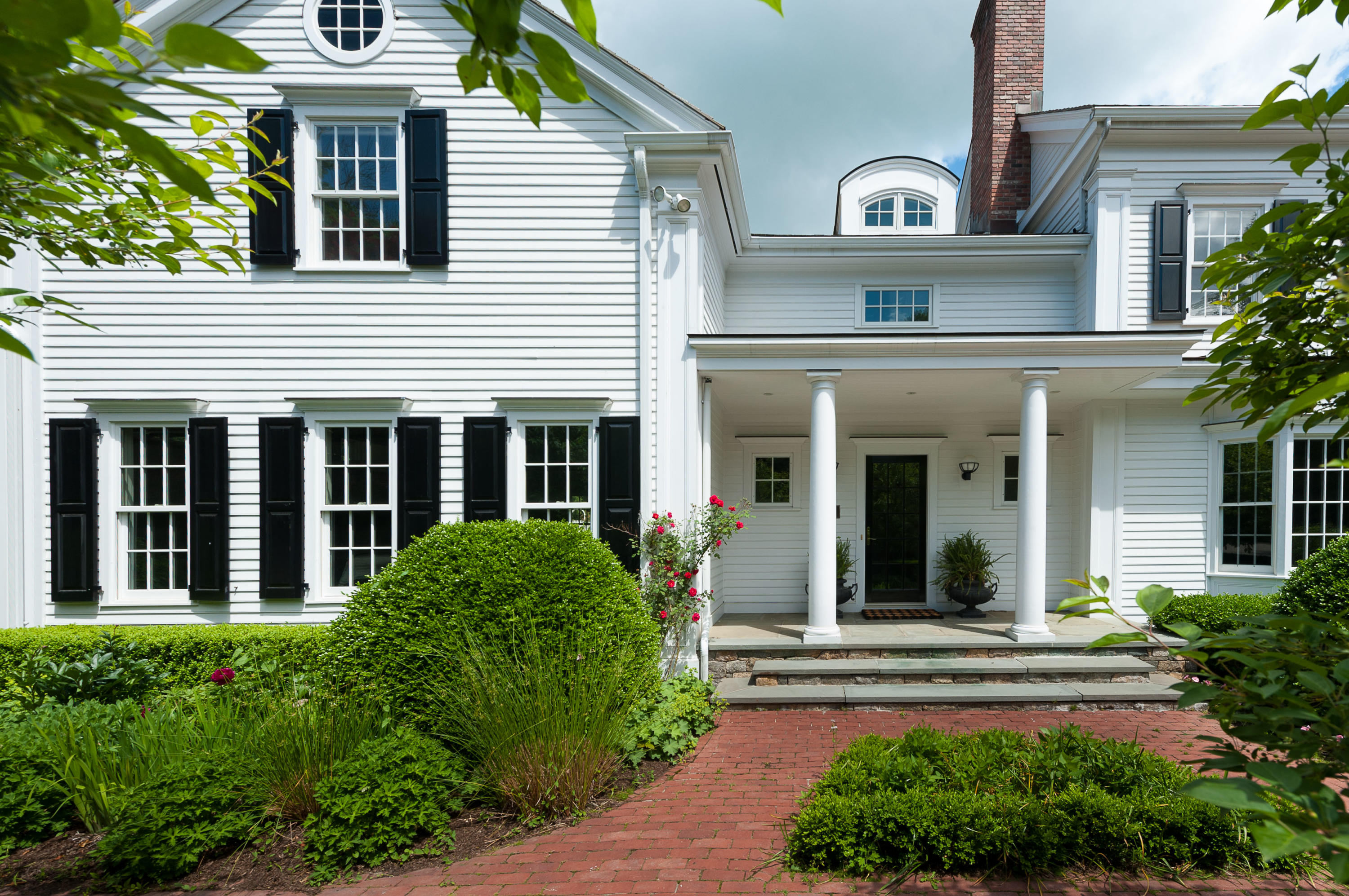399 Wahackme Road New Canaan, CT 06840 - Photo 3 of 35 a view of a white house with large windows and a table and chairs in a yard