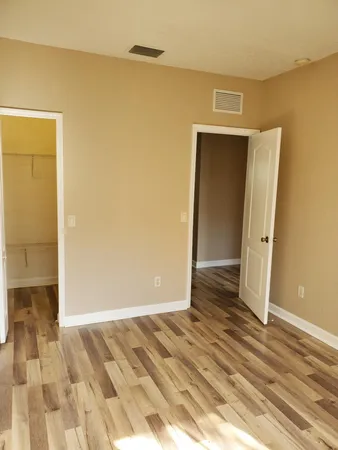 a view of a room with wooden floor and a bathroom