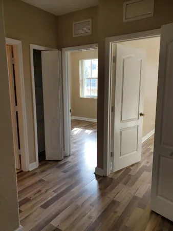 a view of a hallway with wooden floor