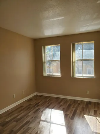a view of a room with wooden floor and windows