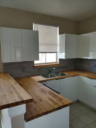 a kitchen with granite countertop a sink and white cabinets