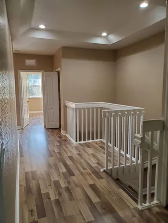 a view of a hallway with wooden floor