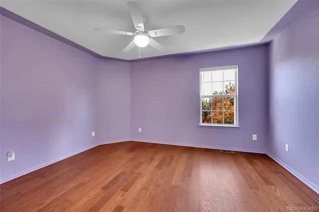 a view of an empty room window and wooden floor