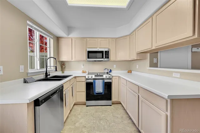 a kitchen with stainless steel appliances granite countertop a sink stove top oven and microwave