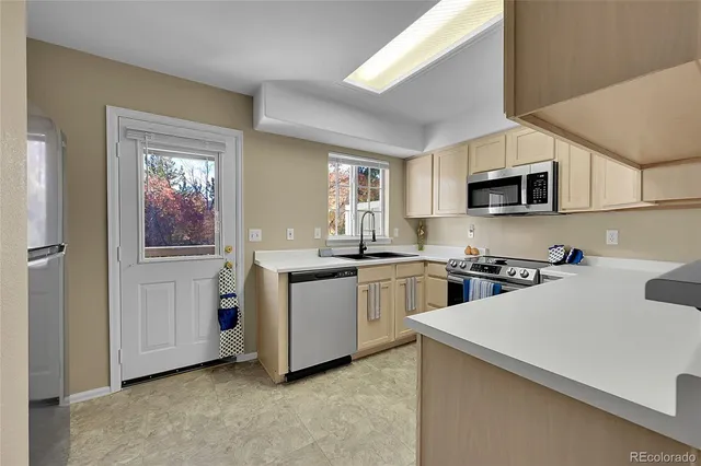 a kitchen with sink a microwave and cabinets