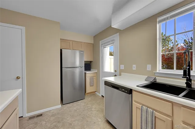 a kitchen with stainless steel appliances granite countertop a refrigerator and a sink